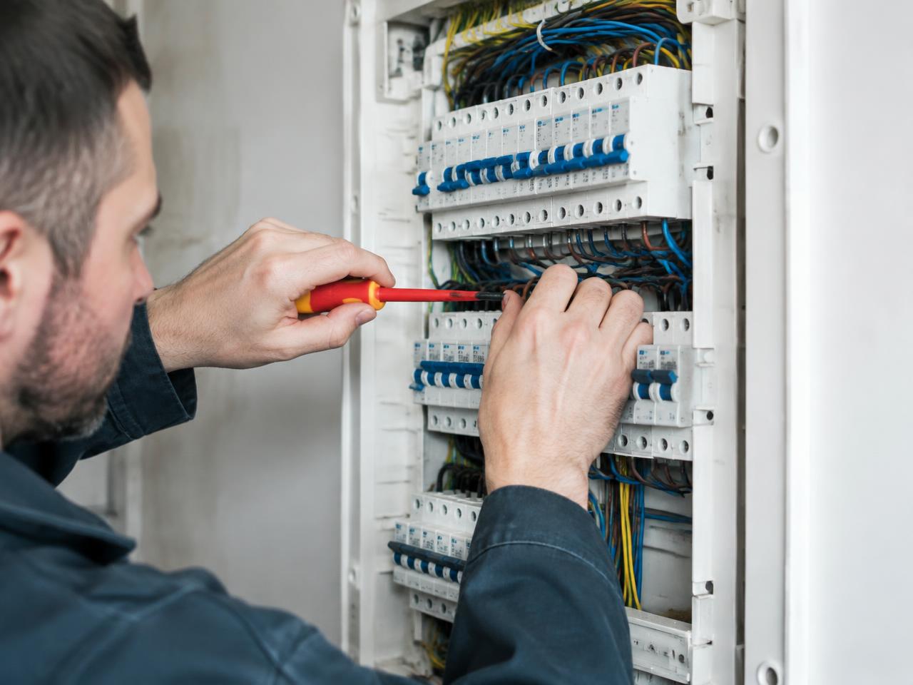 Elektriker arbeitet am Sicherungskasten